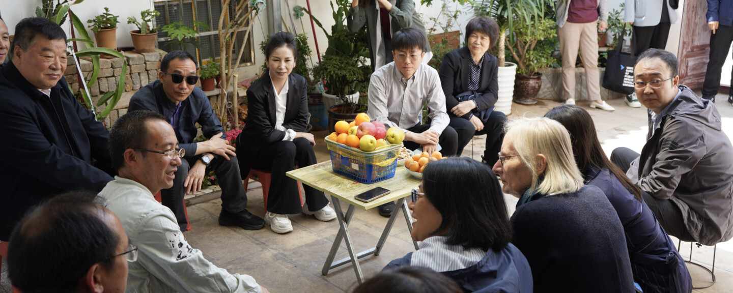 A farmer, Winnie Yip and other commissioners discuss the poverty relief and healthcare program